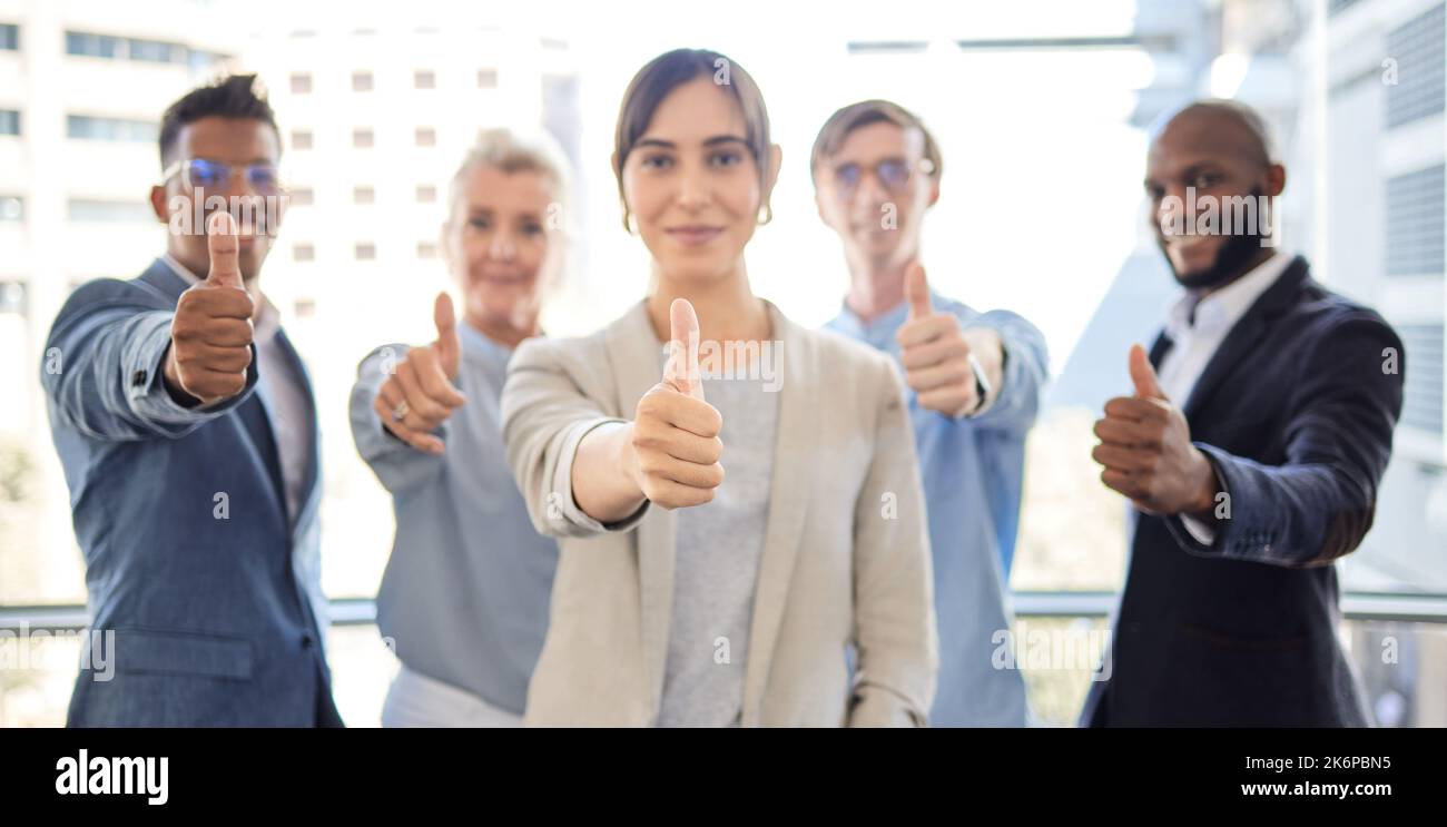 There are great rewards waiting for you at the end. Closeup shot of a group of businesspeople showing thumbs up together in an office. Stock Photo