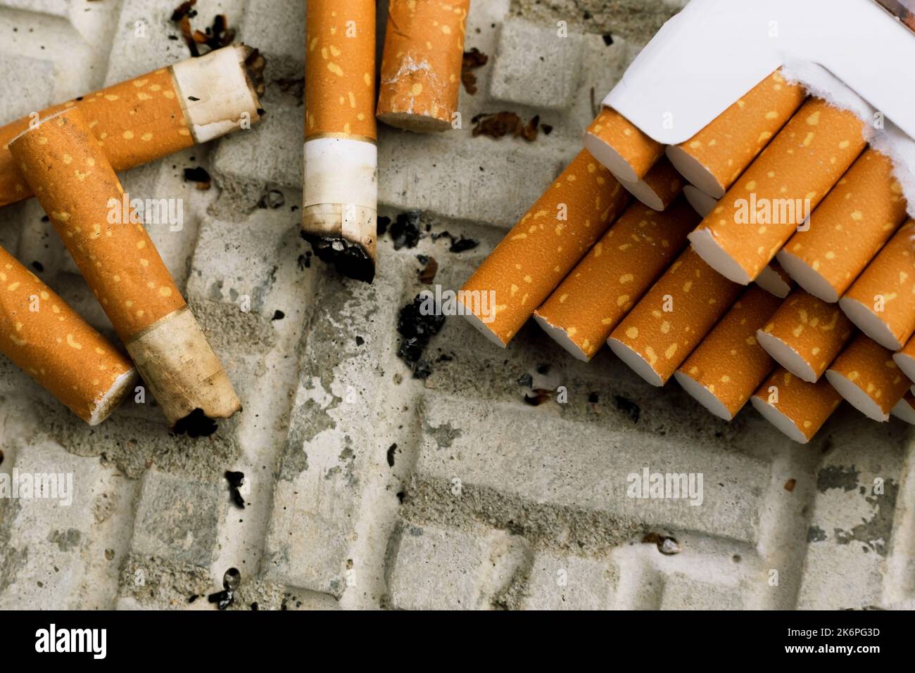 Cigarette. A lot of cigarette butts and matches are lying on the road