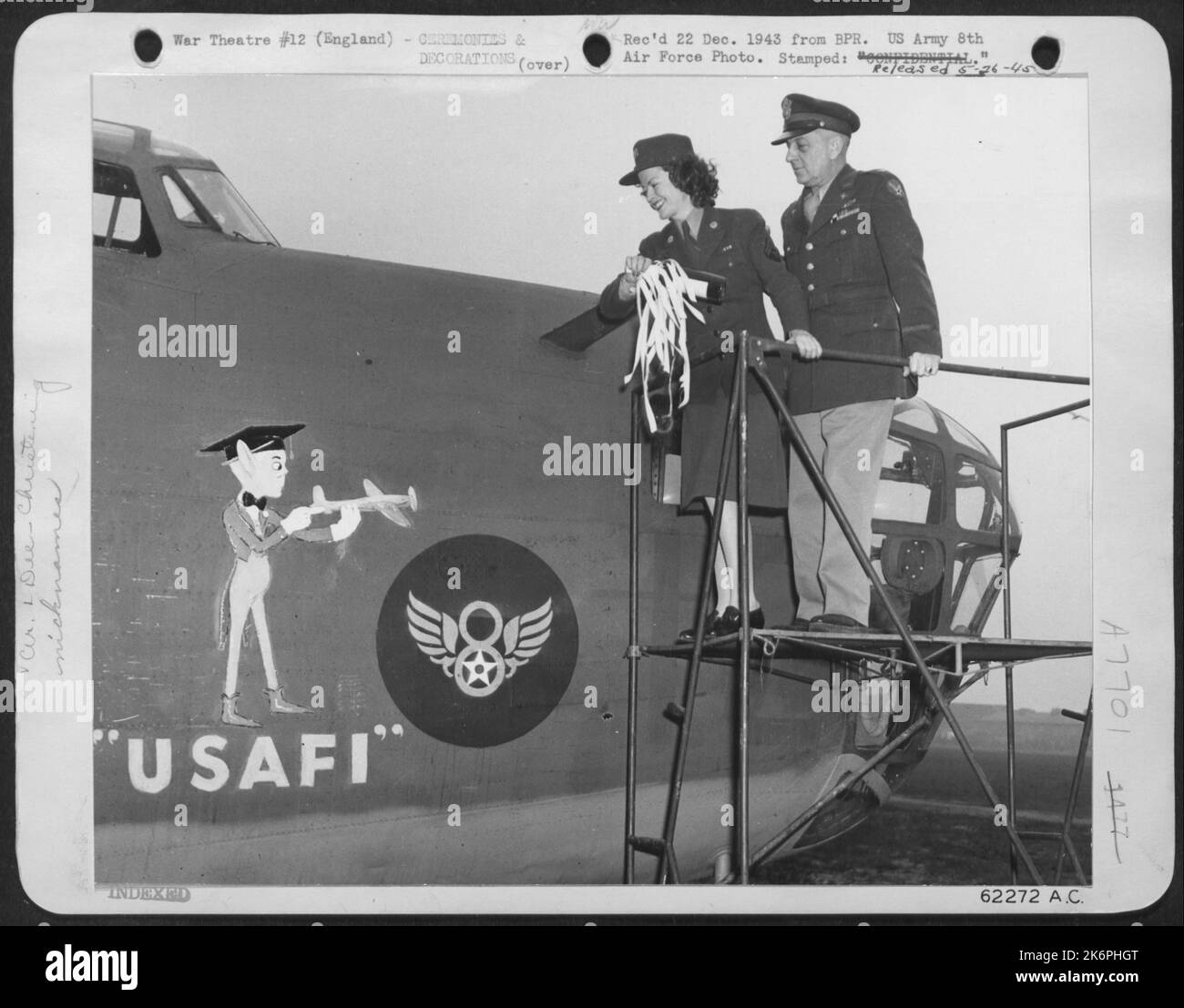Colonel Leslie P. Arnold, Commanding Officer Of The Ferry And Transport Service Assists T/5 Muriel Blum In Christening Converted B-24 Lib 'Usafi' Gremlin 'Usafi' Represents The U.S. Armed Forces Institute Which Is Bringing Education To The Enlisted Man In Stock Photo