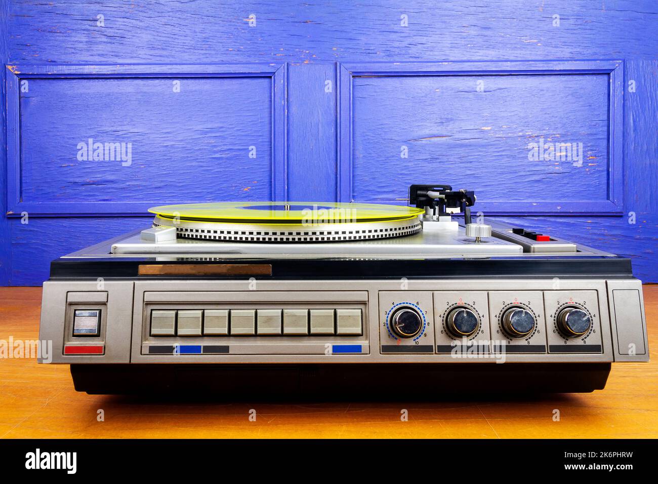 Vintage turntable vinyl record player with yellow vinyl on a table ...