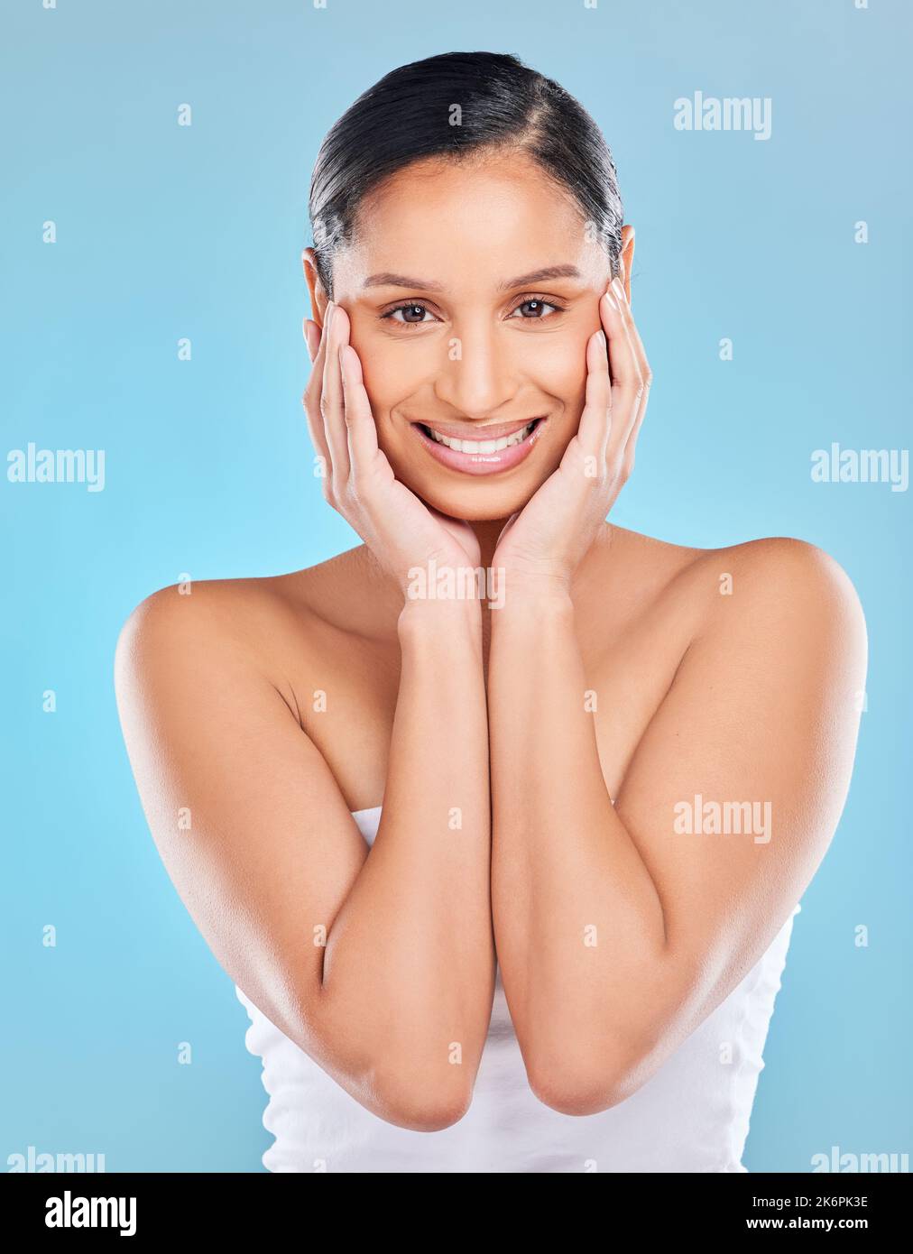 My skin is the softest its ever been. Studio portrait of an attractive young woman posing against a blue background. Stock Photo