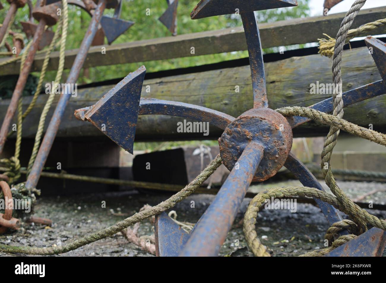 Rusty Anchors and Maritime Equipment on a Wooden Dock at Daytime Stock Photo