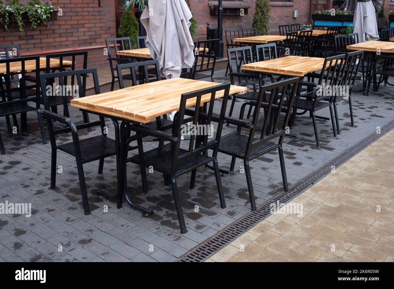 Cafe table and chairs on the street KALiningrad. Wooden table with black chairs Stock Photo