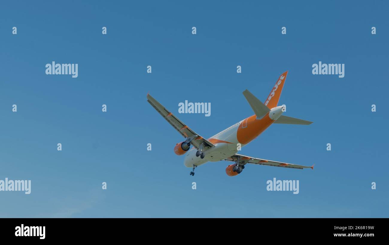 Airplane flying in a blue sky Stock Photo - Alamy