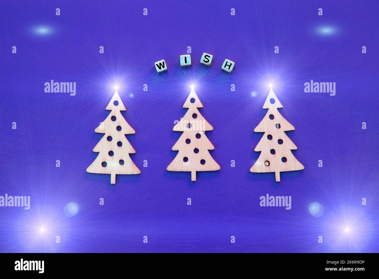 New Year wooden ornaments, top view. Wooden Christmas tree. Violet background. Flat lay style. Place for text. Christmas concept. Inscription wish Stock Photo
