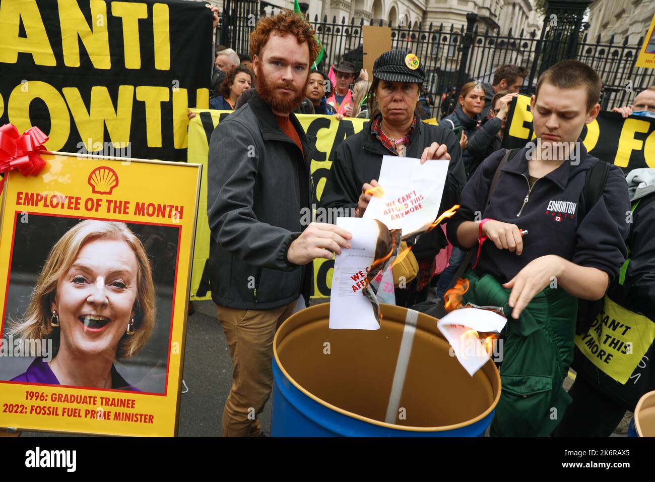 London, UK. 14th Oct, 2022. 14th October 2022, London, UK. Extinction Rebellion protestors hold up flares and banners as they burn fake gas bills outside the gates of Downing Street in London. Credit: Isles Images/Alamy Live News Stock Photo