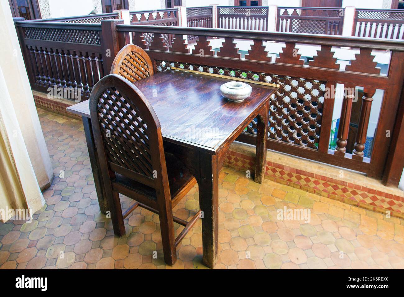Some wooden table and chairs in arabic decoration and wooden railings