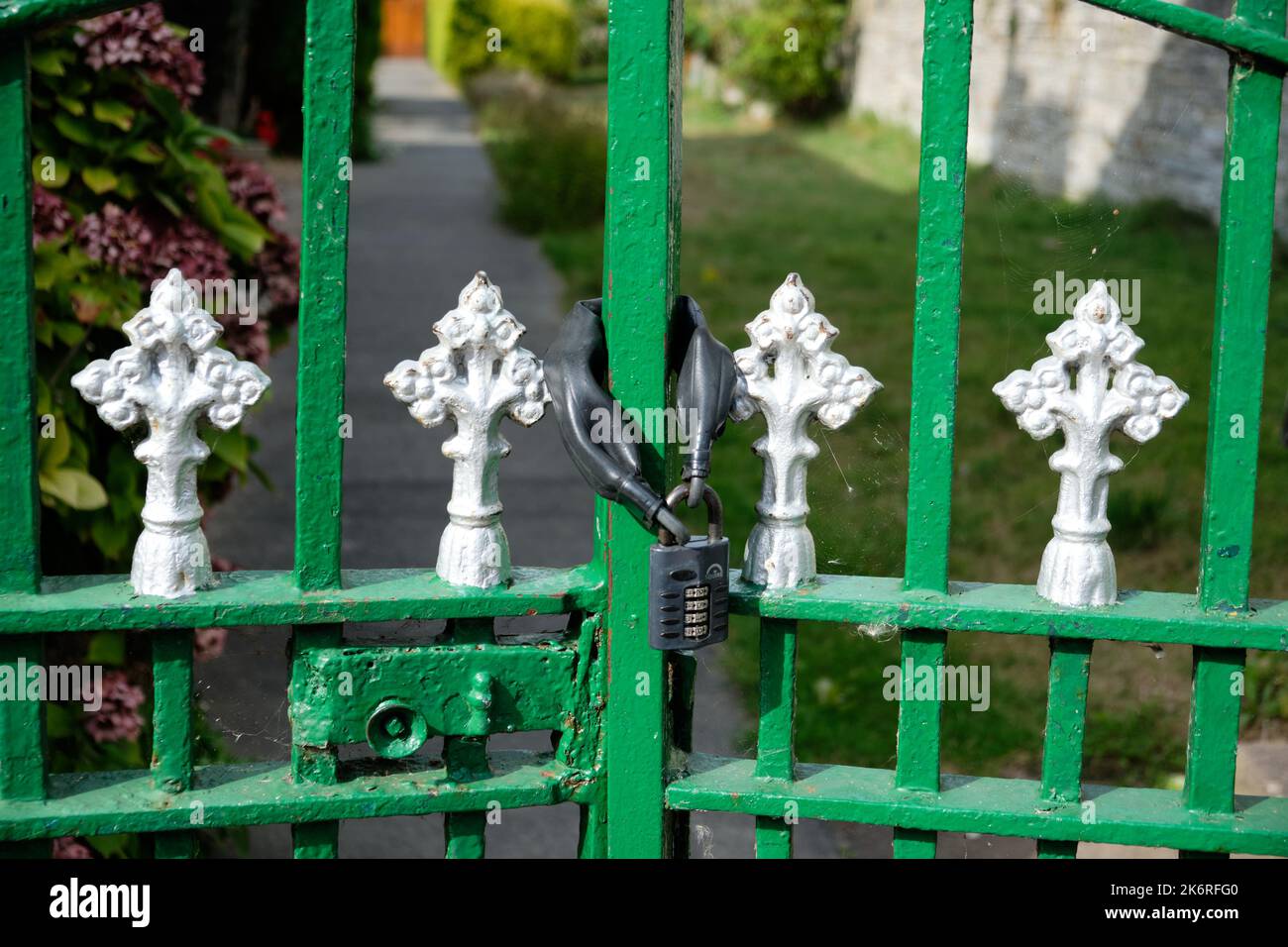 Padlocked green gate Stock Photo