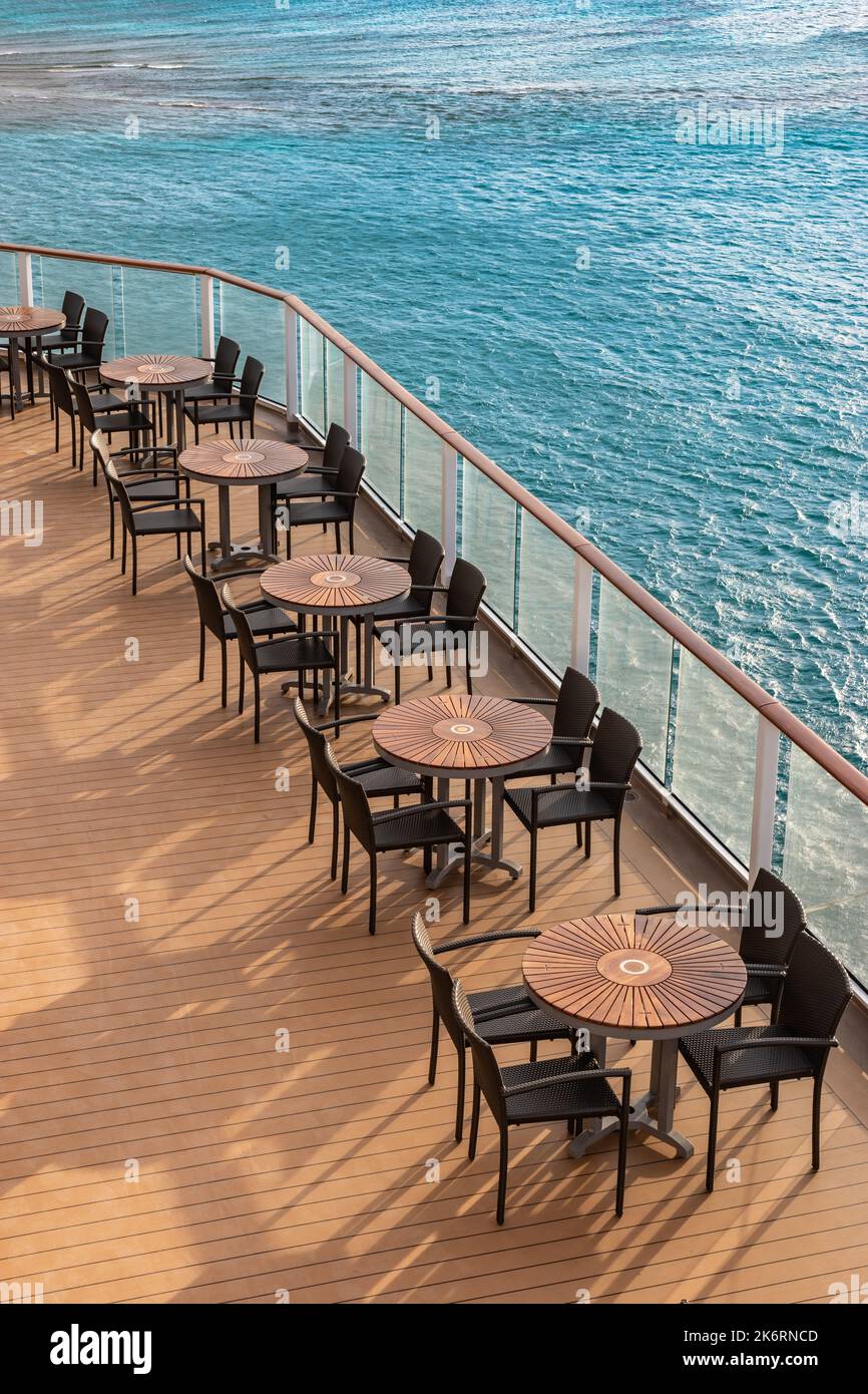 Outdoor furniture on cruise ship. Empty tables and chairs on deck. Stock Photo