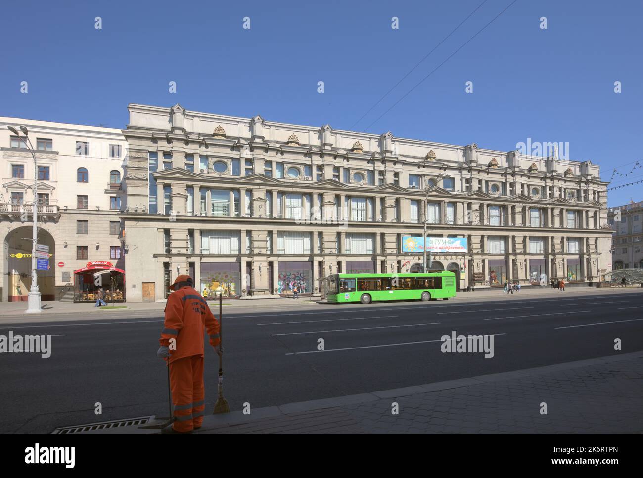 Worker of communal cleaning service against the building of GUM, the State Shopping Centre, in Minsk, Belarus Stock Photo