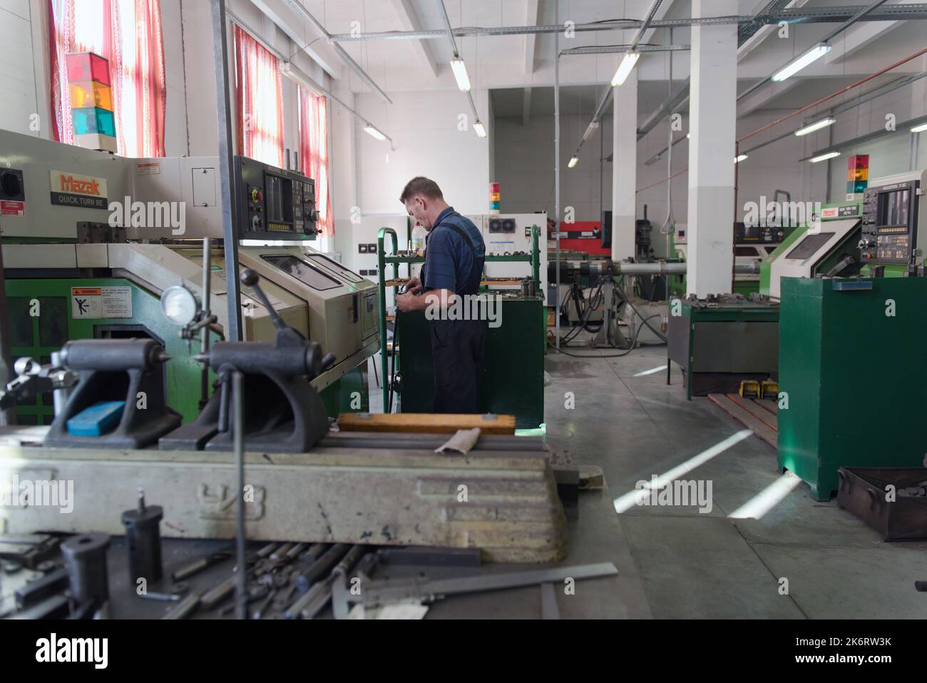 Worker of the holding Lenpolygraphmash on his workplace at the Mazak Quick Turn 8e turning centre Stock Photo