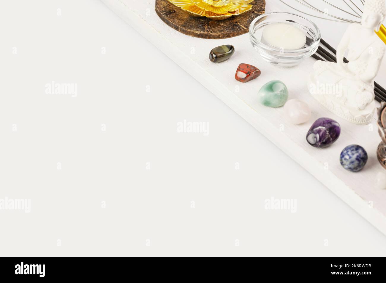 buddha figurine, chakra stones, candle and aroma sticks on a white background Stock Photo