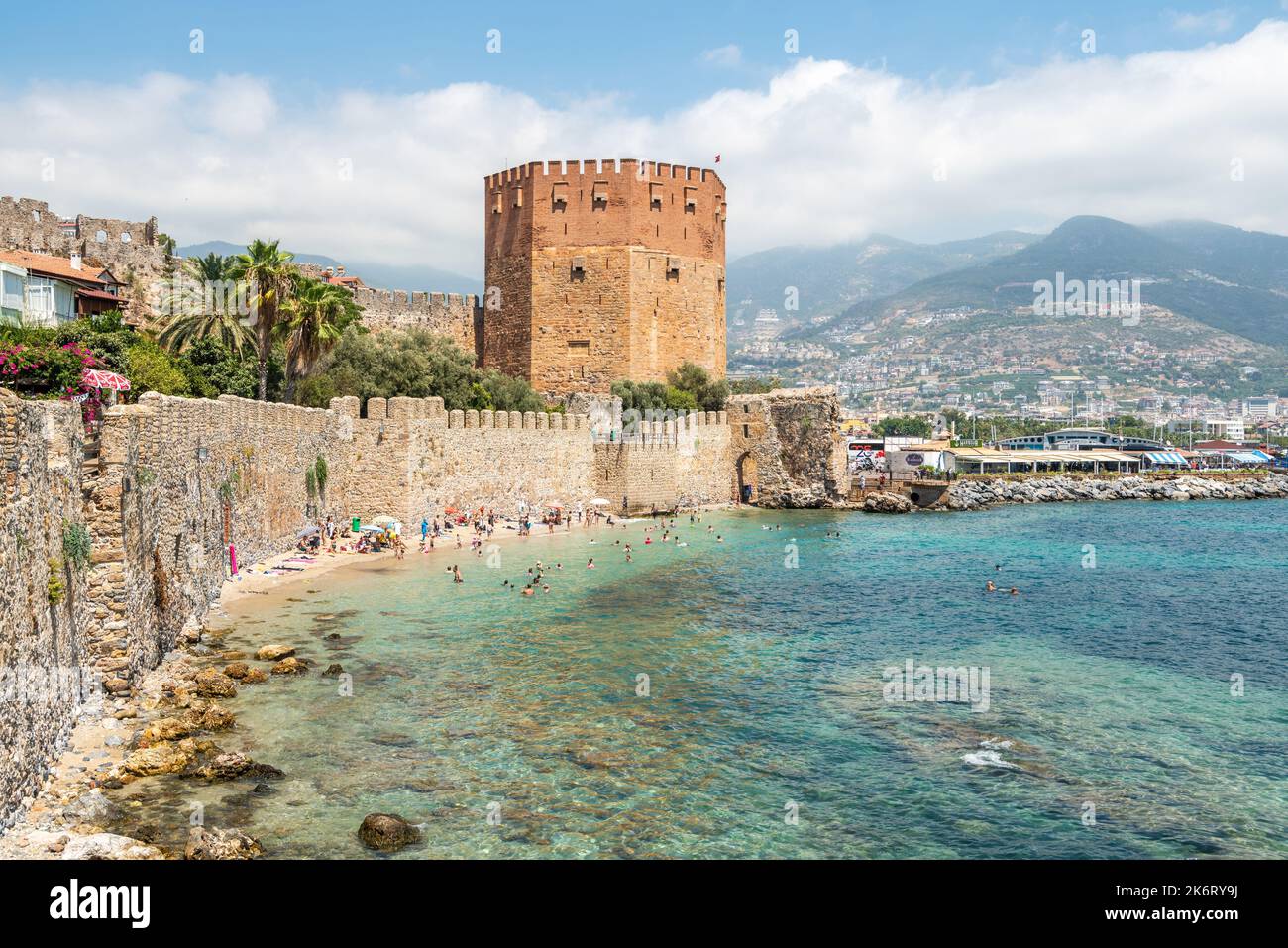Alanya, Turkey – August 18, 2021. View toward old harbour walls and Red Tower in Alanya, Turkey. The five-storey octagonal defence tower was construct Stock Photo
