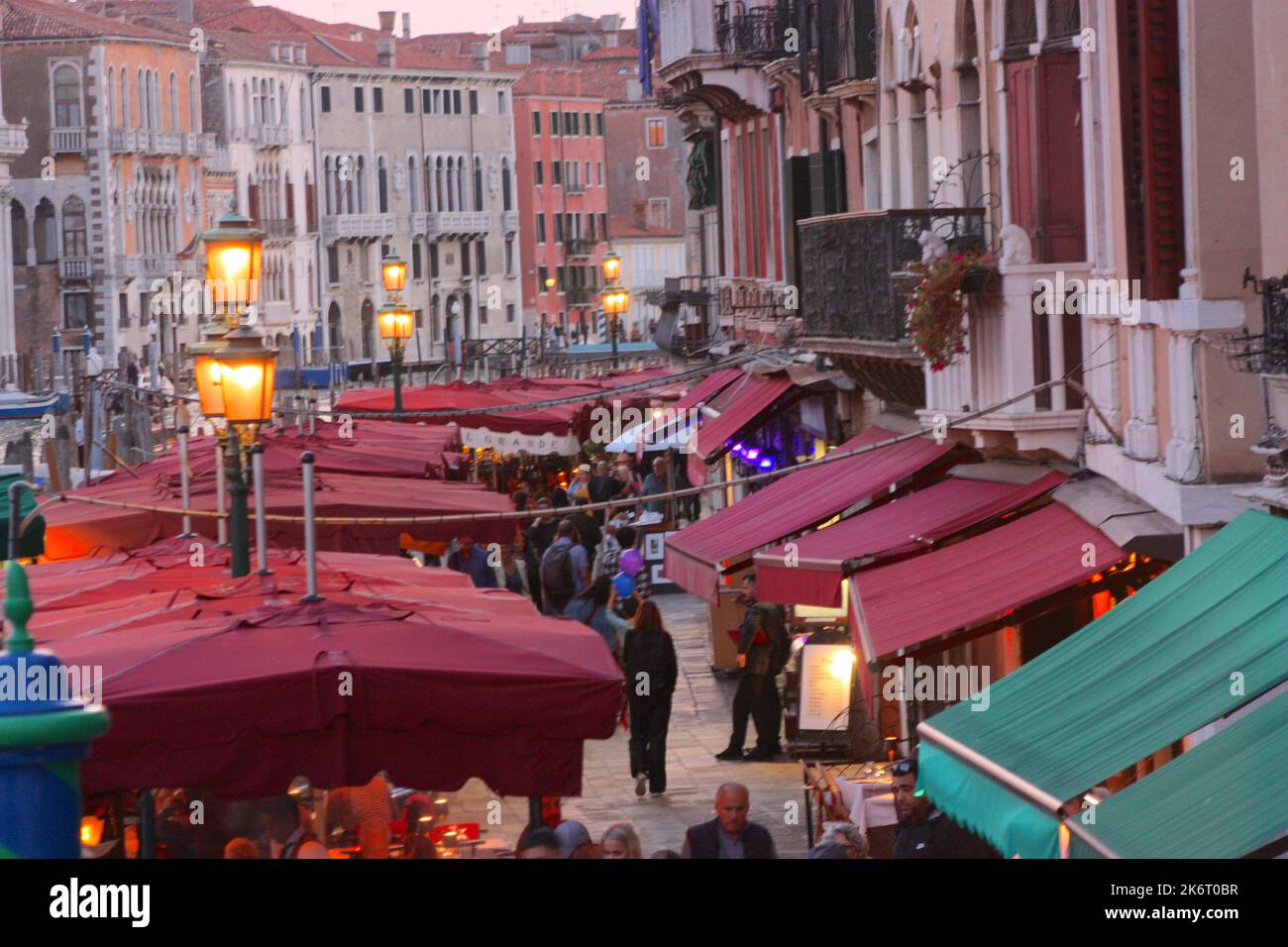Restaurants at sunset near Rialto Bridge in Venice Stock Photo
