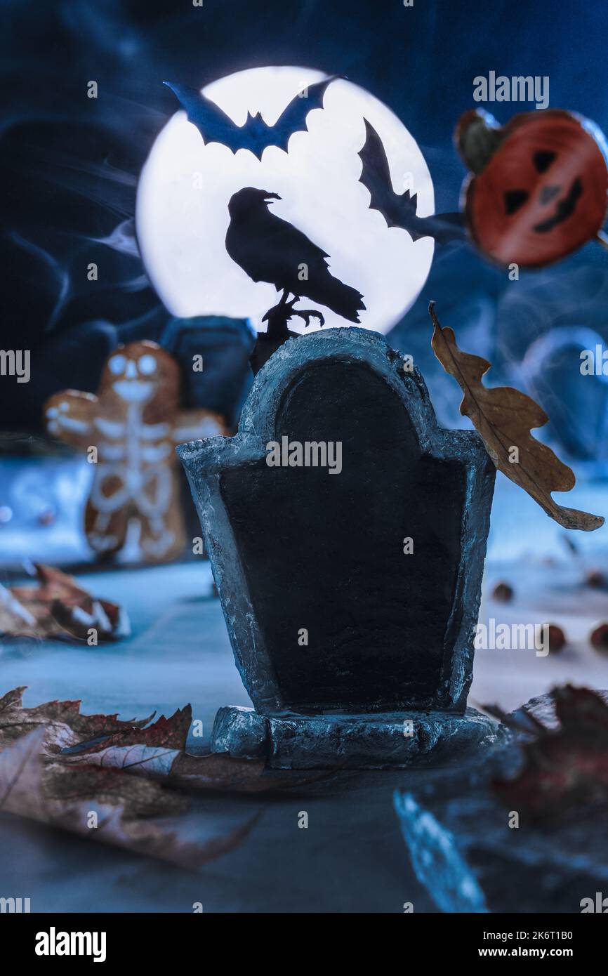 Close up of a tombstone in a cemetery. Copy space. Scary cemetery in fog at night by the light of the moon, crows, bats. Rising from the dead zombies. Stock Photo