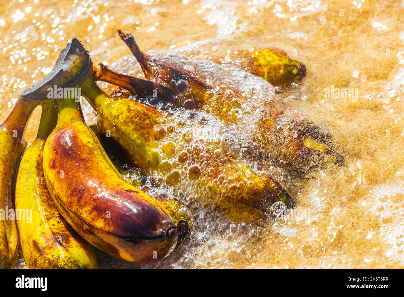 Banana bundle fruits floats in water on beach in Playa del Carmen