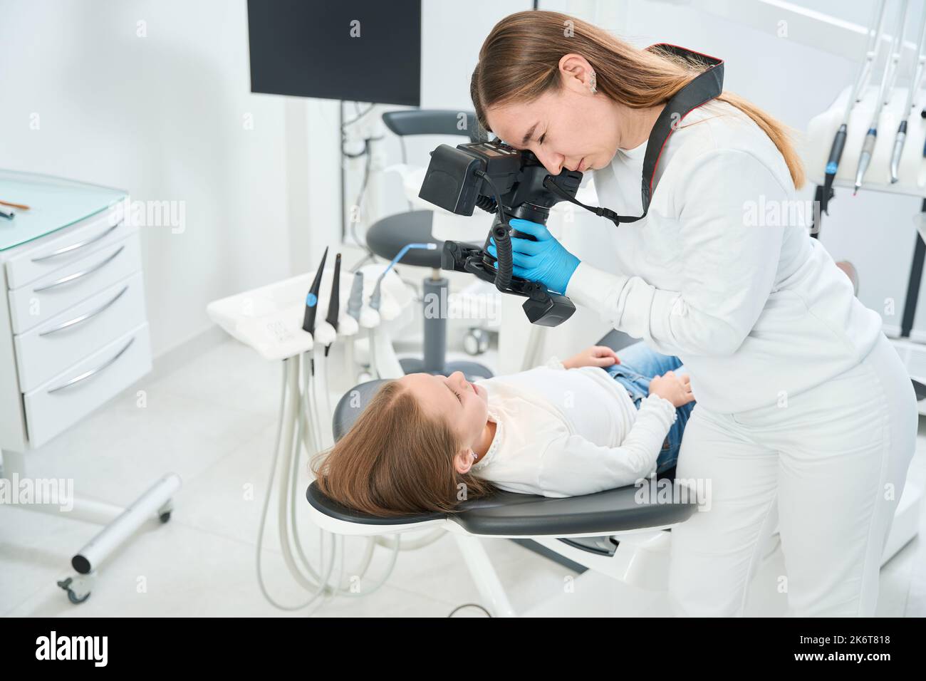 Pediatric dentist taking images of child mouth during consultation Stock Photo