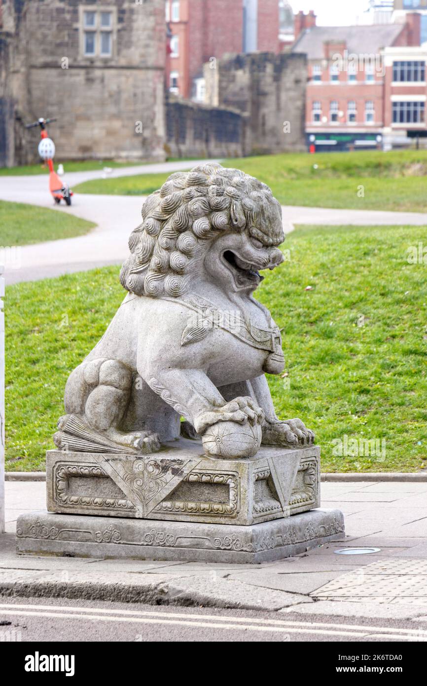 stone lion statue next to chines arch entrance to chinatown in Newcastle upon Tyne uk Stock