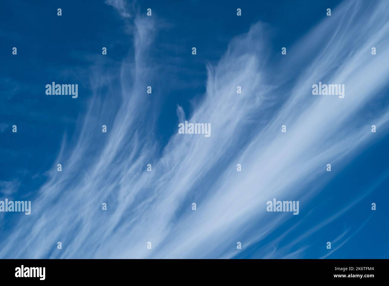 Wispy white clouds against a bright blue sky Stock Photo