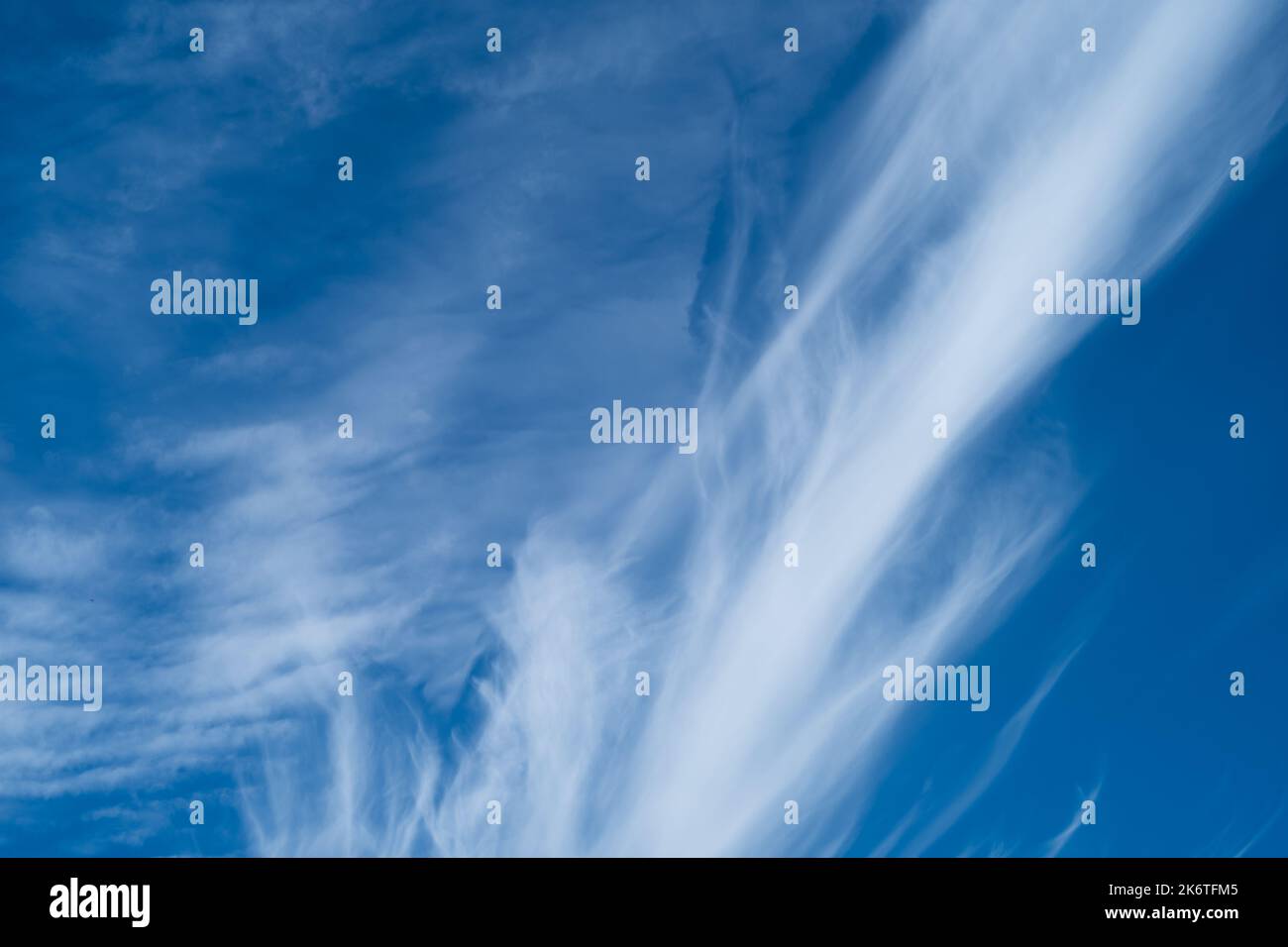 Wispy white clouds against a bright blue sky Stock Photo