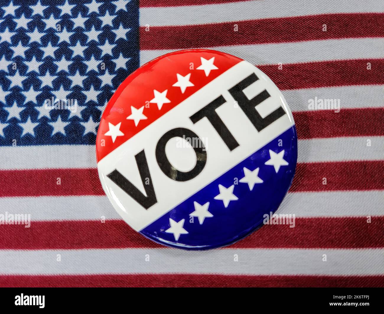 Close up of a vote campaign button on an American flag Stock Photo