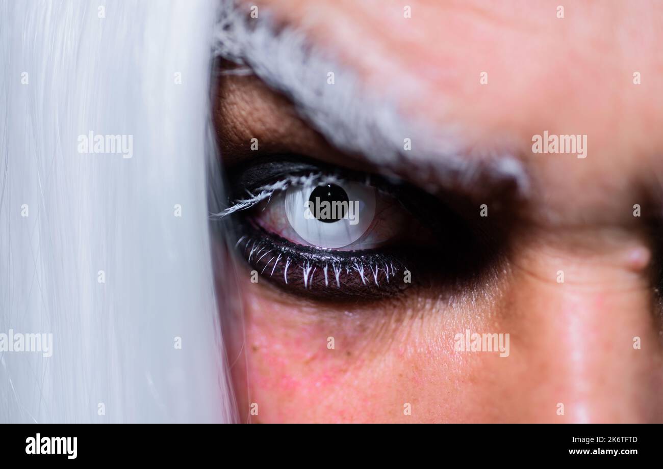 Halloween makeup. Devil, Vampire or Monster Eye Lens. Closeup of man eyes. Horror and scary concept. Stock Photo