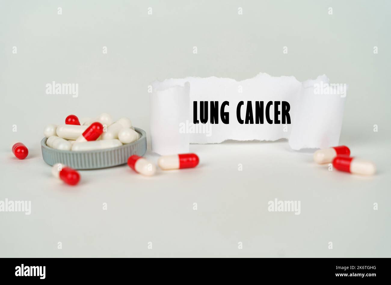 Medical concept. On a gray background, medical capsules and a paper plate with the inscription - Lung cancer Stock Photo