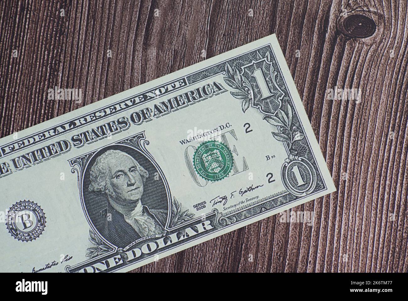 Fake US one dollar bill laying on wood table. Stock Photo