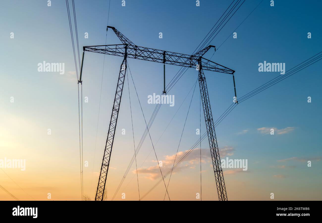 High voltage towers with electric power lines at sunset Stock Photo - Alamy