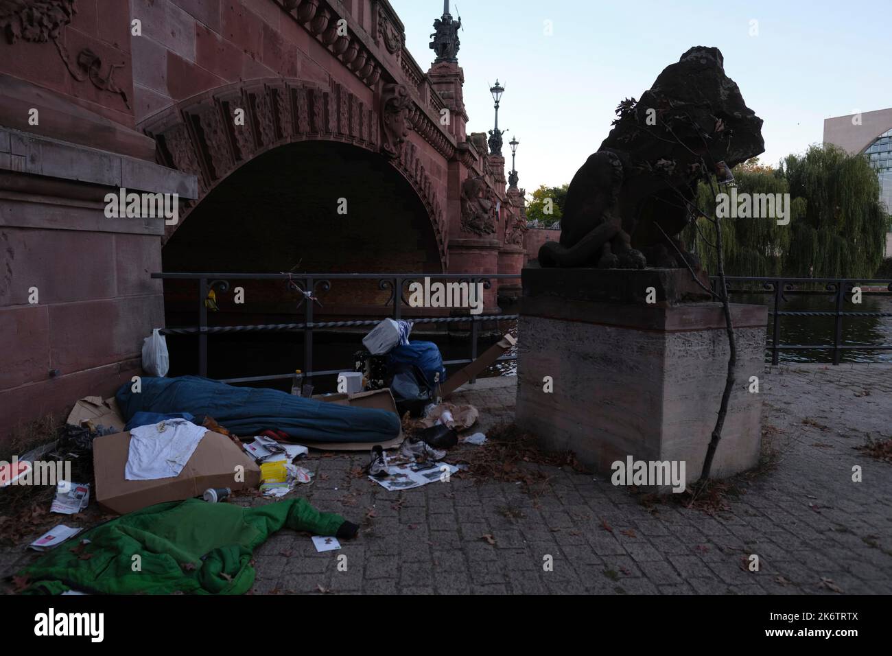Germany, Berlin, 09. 10. 201, homeless man sleeping in a sleeping bag surrounded by rubbish, at the Moltkebruecke, Spree, in the background the Stock Photo