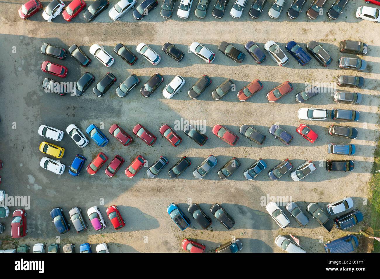 Aerial view of many colorful cars parked on dealer parking lot for sale
