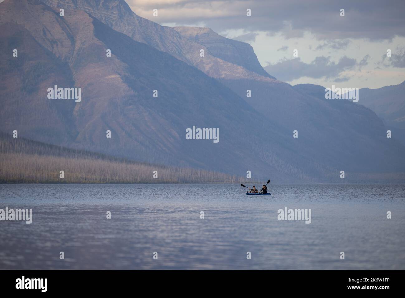 Glacier National Park, Montana USA - September 24 2022: young couple paddle boarding in lake McDonald on a beautiful afternoon. Stock Photo