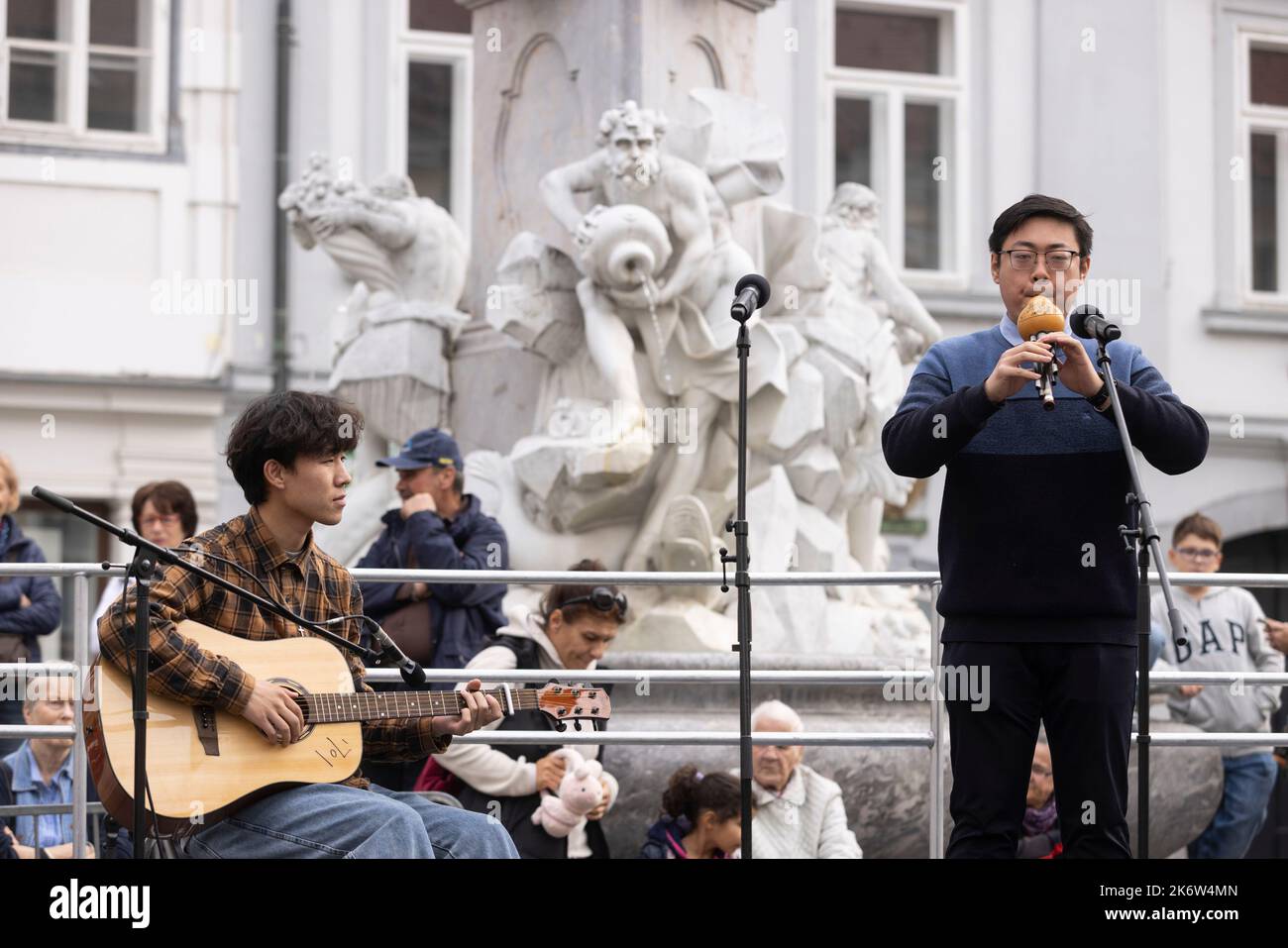 Ljubljana, Slovenia. 15th Oct, 2022. Teachers from the Confucius Institute in Ljubljana perform a cucurbit flute and guitar duet at a charity event in Ljubljana, Slovenia, Oct. 15, 2022. The Confucius Institute in Ljubljana on Saturday showcased Chinese culture at a charity event held in the capital of Slovenia. Visitors had the chance to taste Chinese tea, experience Chinese calligraphy, and put on Hanfu, traditional Chinese clothing, to take photos at the event, which aims at raising fund for Slovenian children in need. Credit: Zeljko Stevanic/Xinhua/Alamy Live News Stock Photo