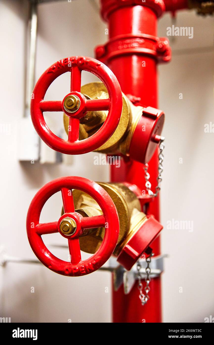 Red standpipe and valve in stairwell for accessing water for emergency fire control Stock Photo