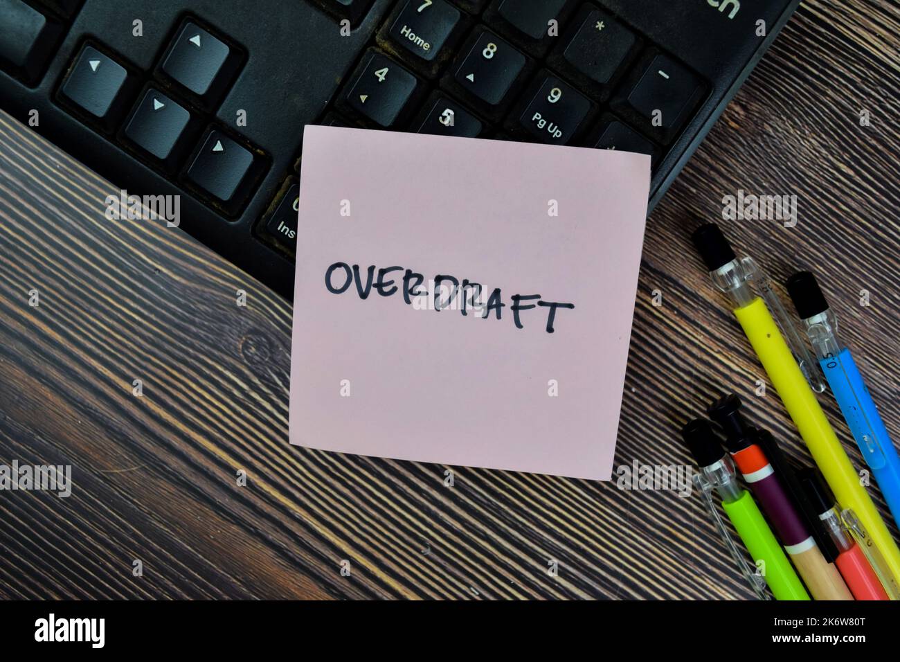 Concept of Overdraft write on sticky notes isolated on Wooden Table. Stock Photo