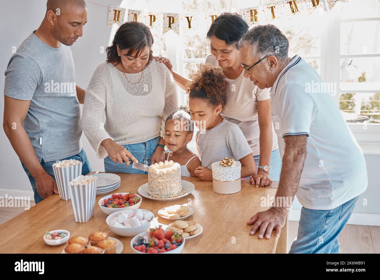 Count your age by friends, not years. a family cutting a cake and celebrating a birthday party at home. Stock Photo