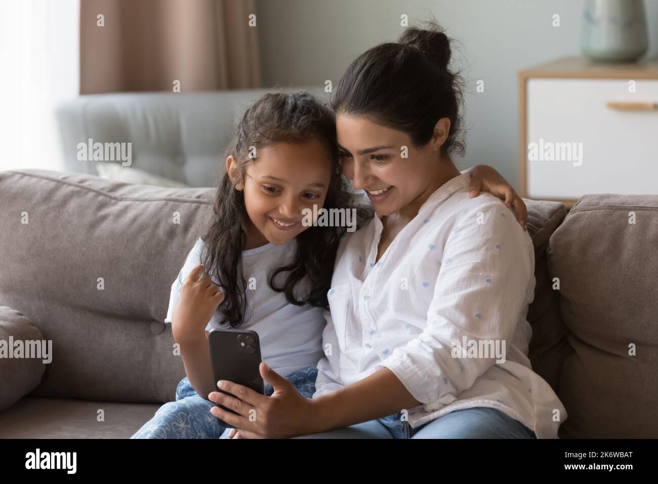 Indian mom and daughter enjoy new apps using smartphone Stock Photo - Alamy