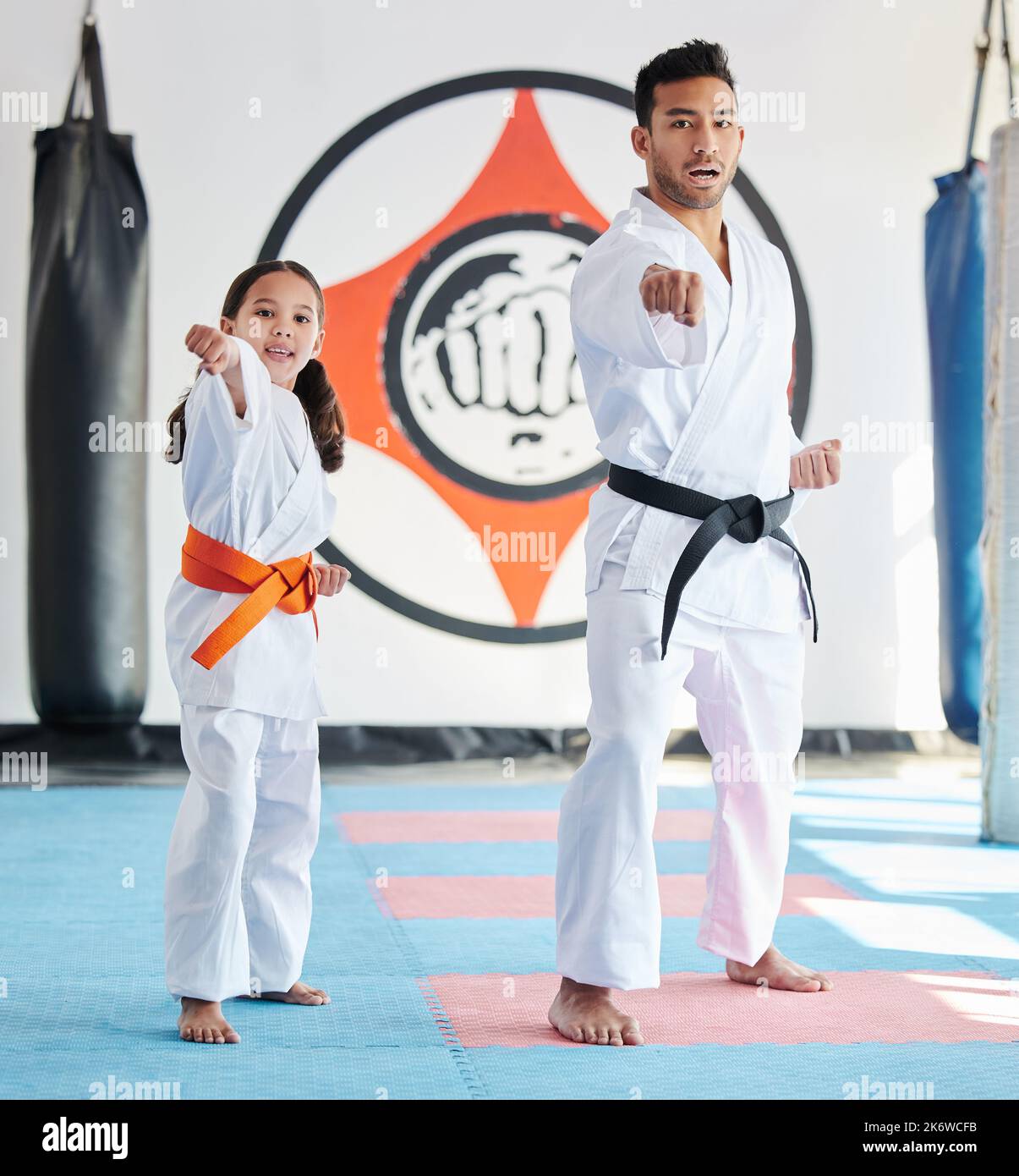 Show them what youre made of. a young man and cute little girl practicing karate in a studio. Stock Photo