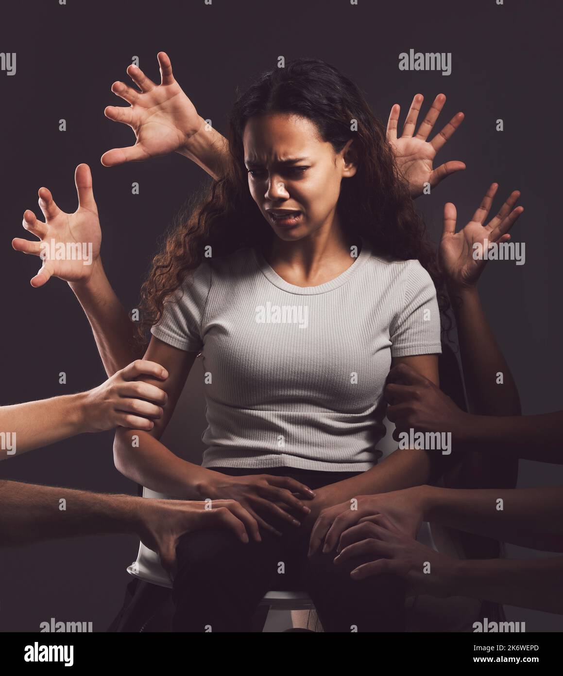 Trauma is hell on earth. hands grabbing a young womans against a dark background Stock Photo Alamy