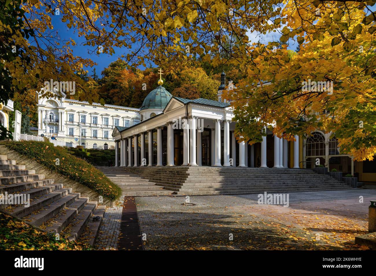 Autumn atmosphere in Czech spa Marianske Lazne (Marienbad) - building of pavilion of mineral water Cross Spring - sunny autumn day, yellow leaves - Stock Image