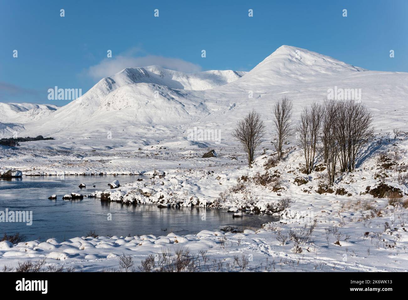 Majestic Winter landscape image looking towards Scottish Highlands mountain range across Loch Ba on Rannoch Moor Stock Photo