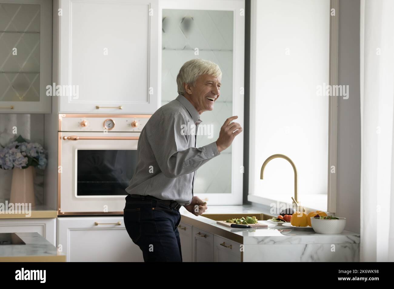 Carefree older man dancing in modern kitchen Stock Photo Alamy