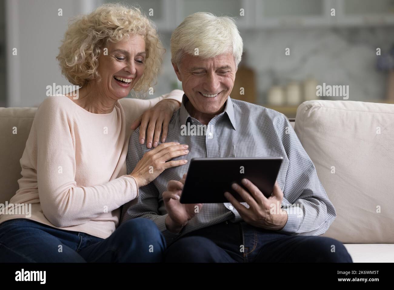 Retired couple spends free time using digital tablet Stock Photo