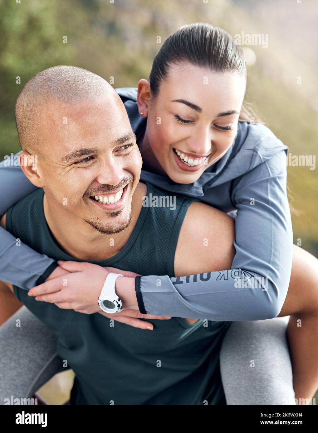 No one is going to hold you down the way I do. a man carrying his girlfriend on his back while out for a workout. Stock Photo