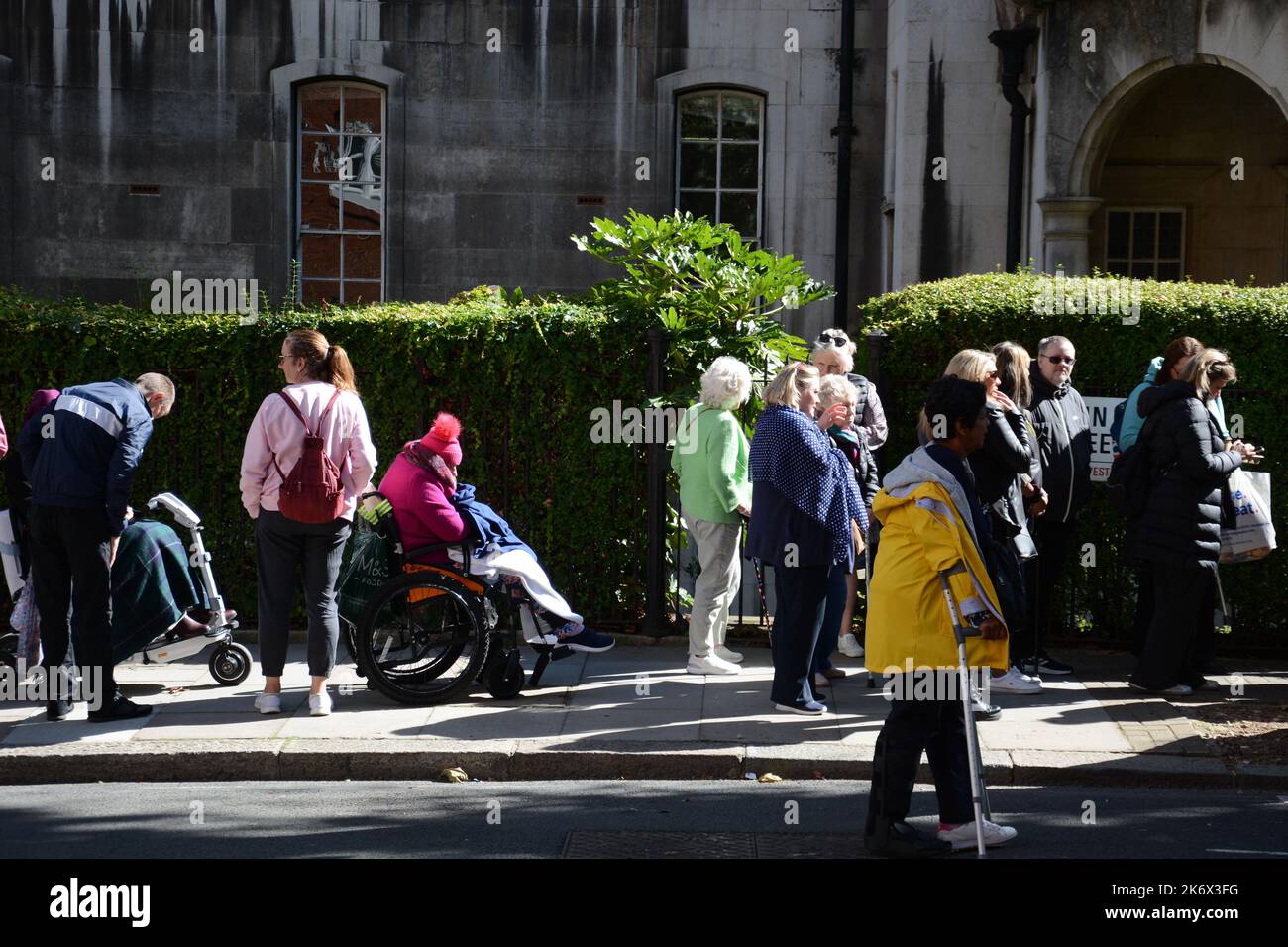 Patient people with accessibility requirements queue to see the coffin ...