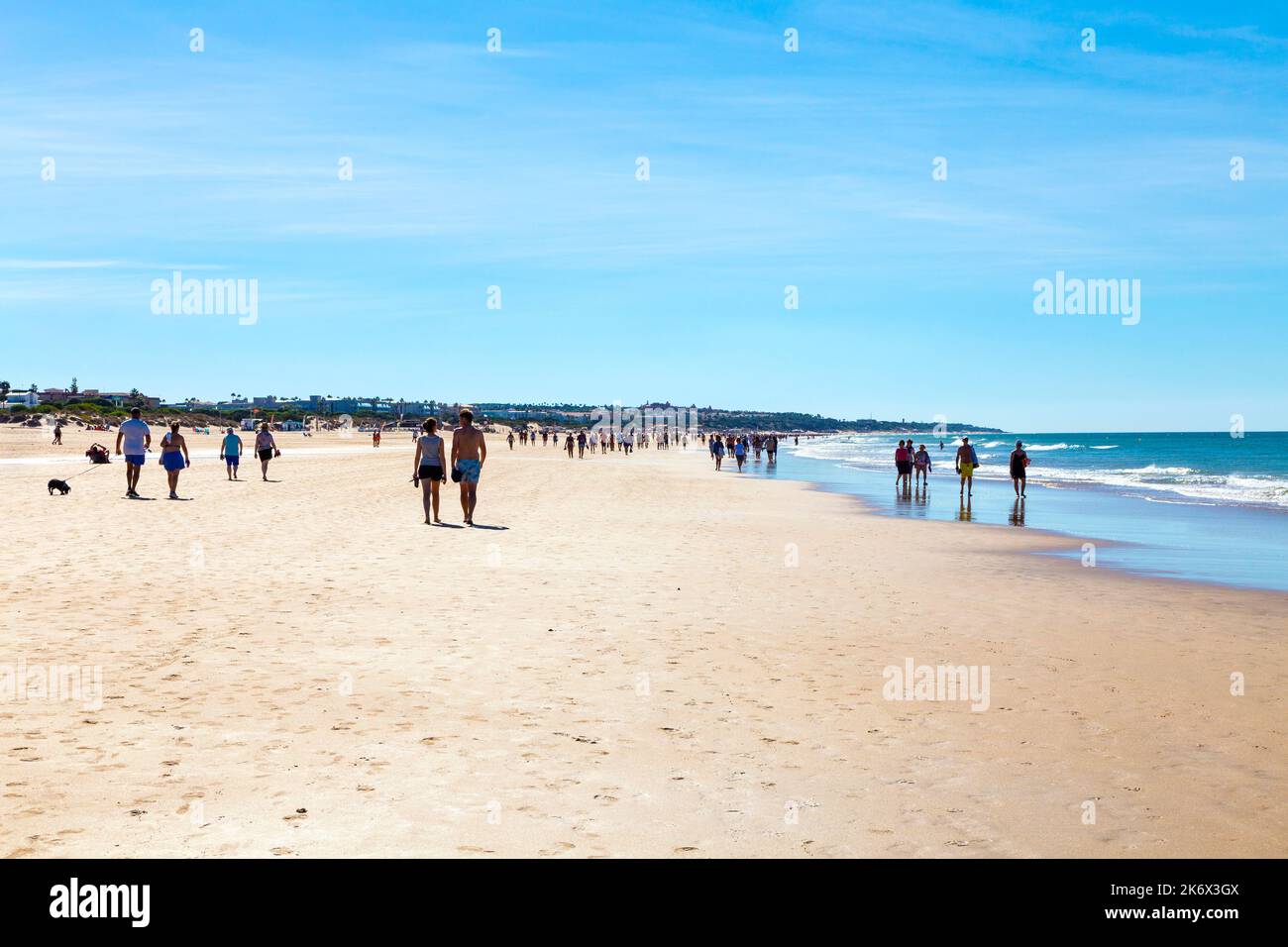 People walking down Playa de la Barrosa, Cadiz, Spain Stock Photo