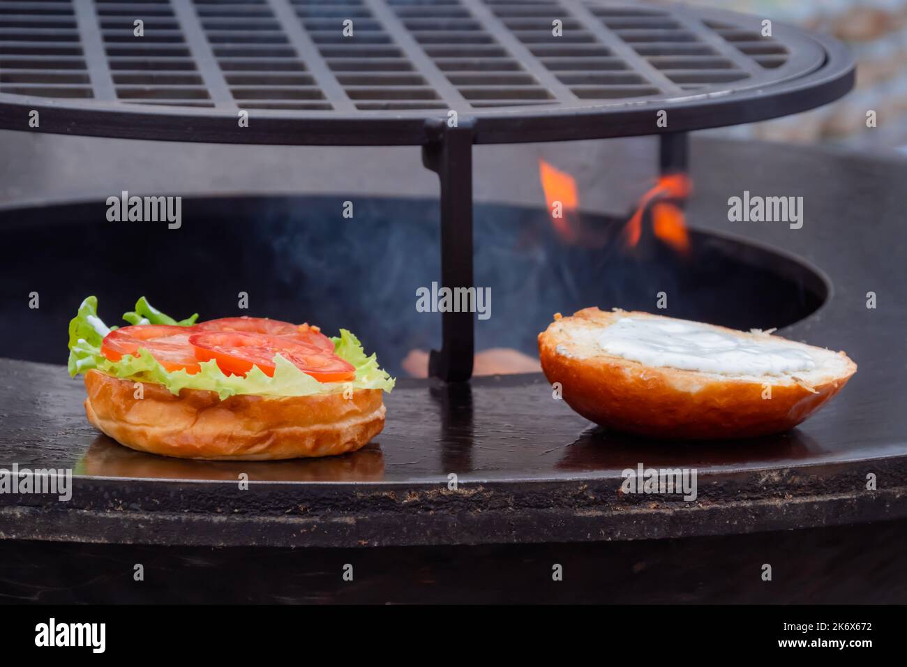 Process of cooking burger on brazier at summer food market Stock Photo
