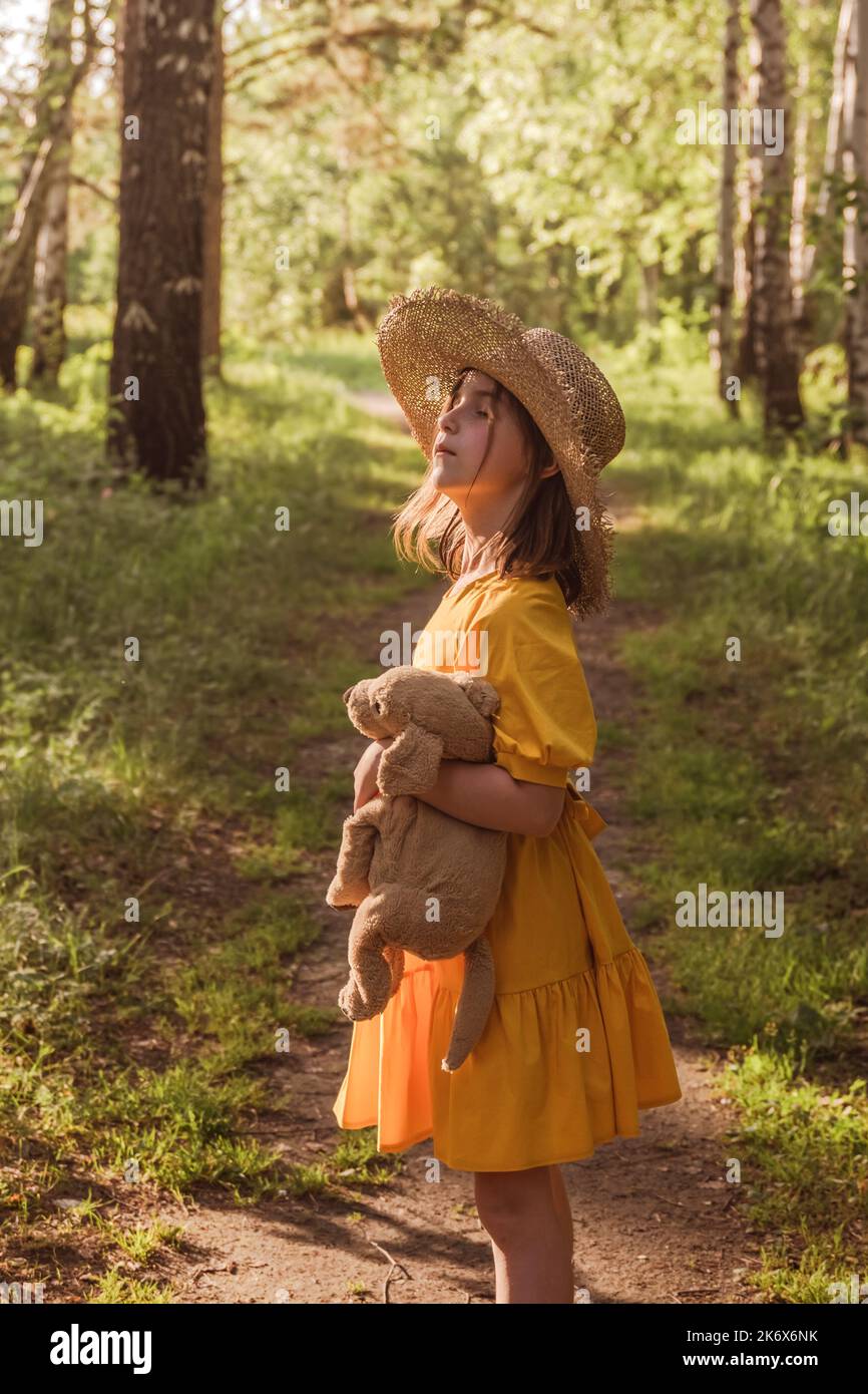 cute little girl in a yellow dress and straw hat walking through the ...