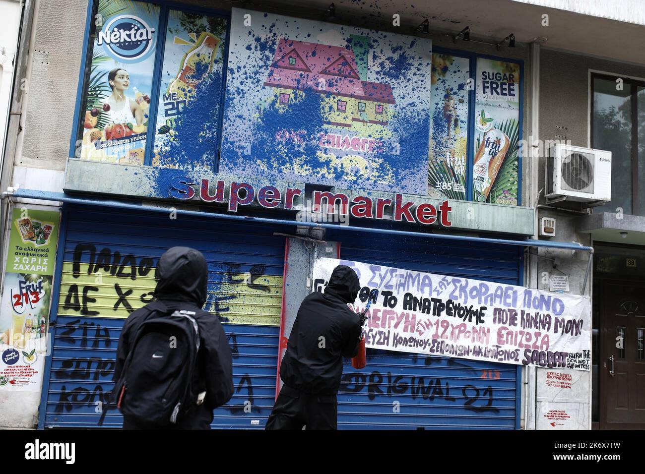 Protesters throw paint at the shop of Ilias Michos in Kolonos, Athens, a  local market owner who raped and prostitute a 12-year-old girl. Protest and  march against rapes and the attempt to