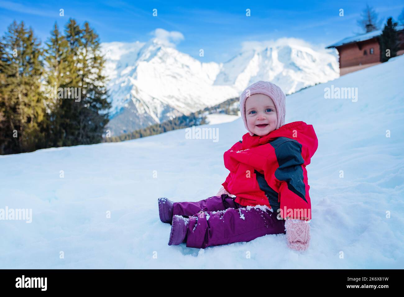 Profile view of a happy girl sit in snow wear winter outfit Stock Photo
